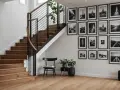 Galeria czarno-białych zdjęć architektonicznych i krajobrazowych zdobi ścianę przy drewnianych schodach.