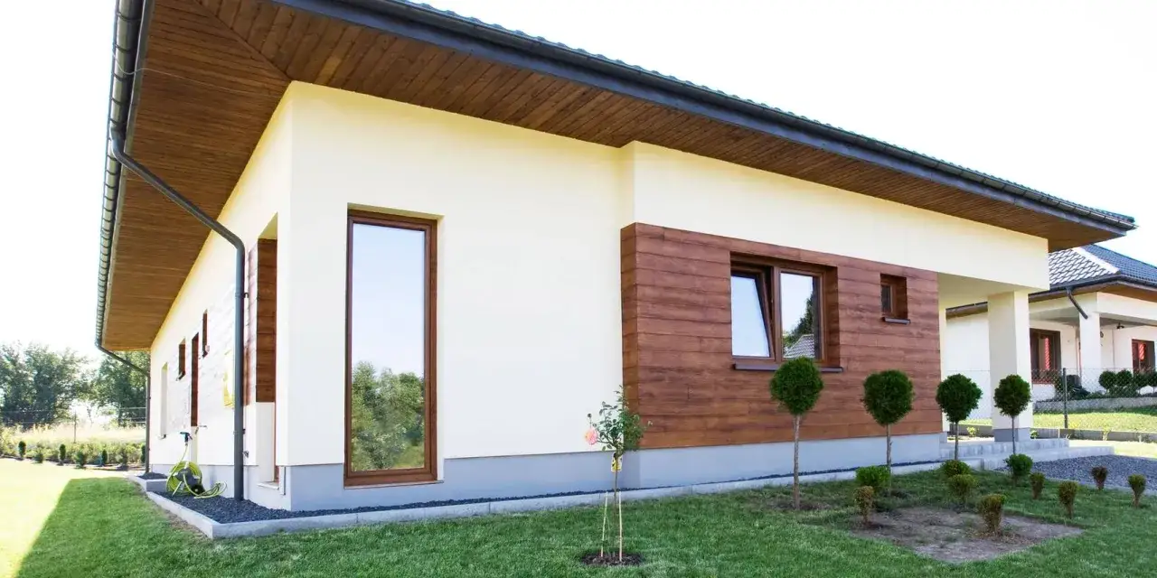 Jasna elewacja domu z drewnianymi akcentami. Zastanawiasz się, jaka farba do elewacji domu nada mu taki nowoczesny wygląd?
